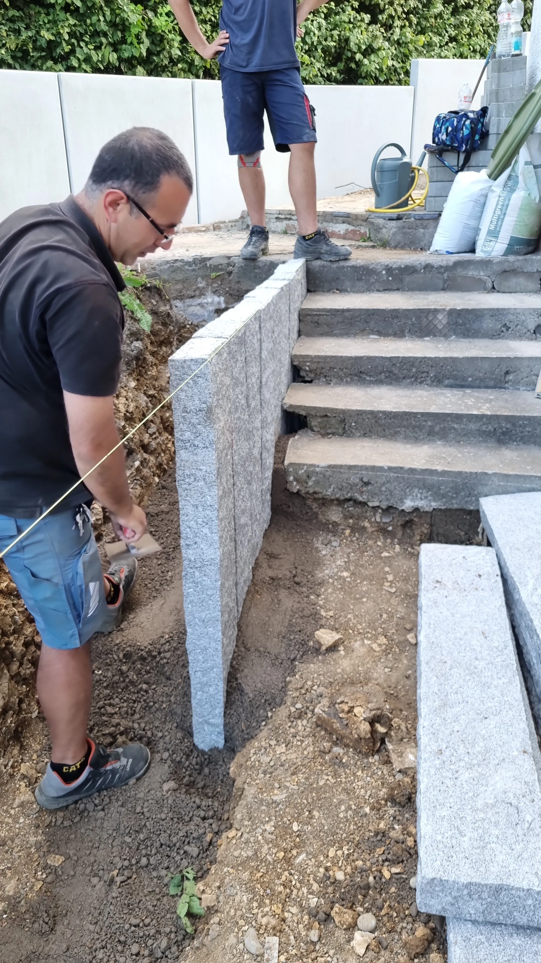 Blockstufen aus Granit an einem Hang, beim Setzen mit der Richtschnur.