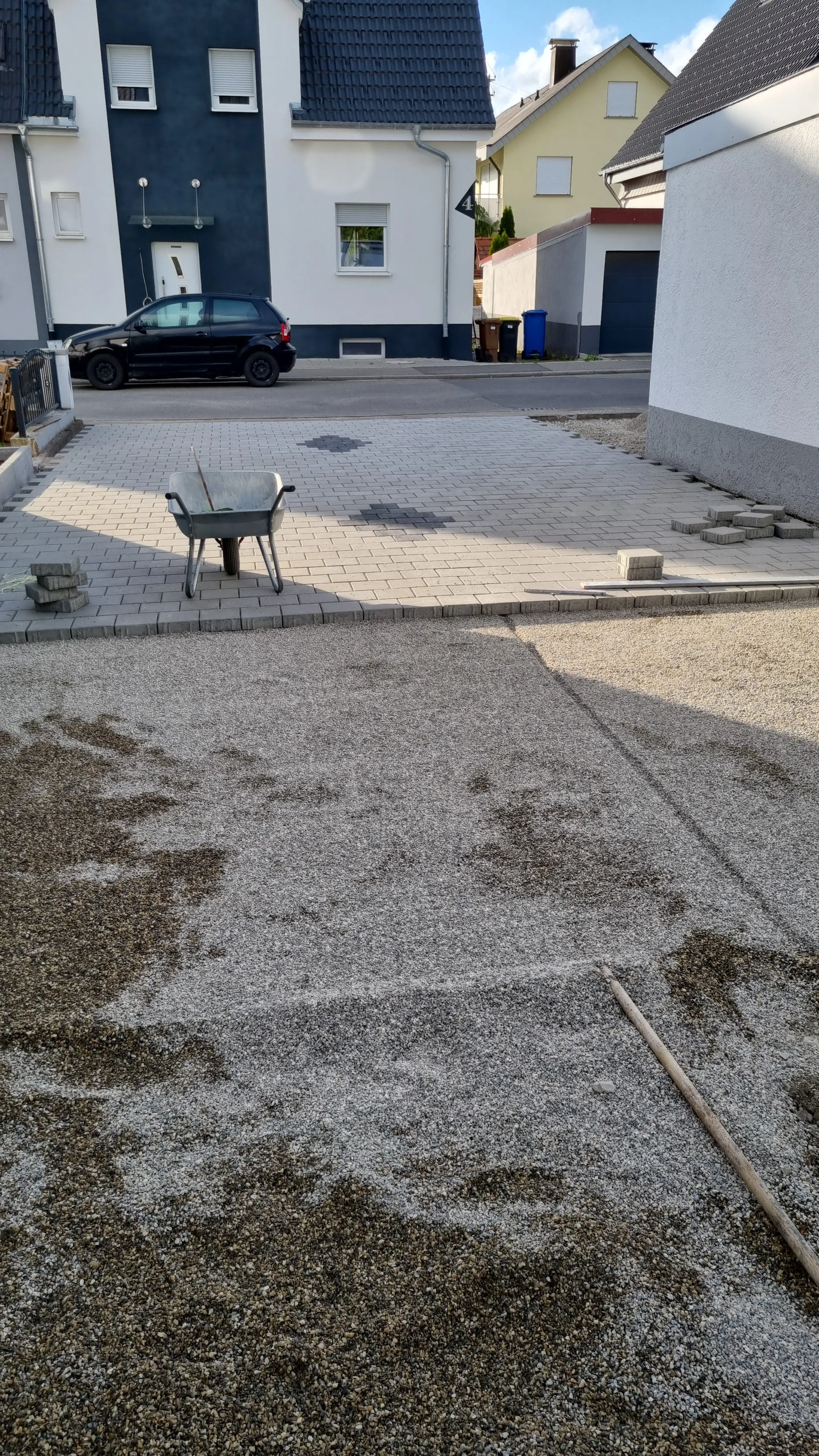 Hof mit vorbereitetem Splittbett und ersten Pflastersteinen.